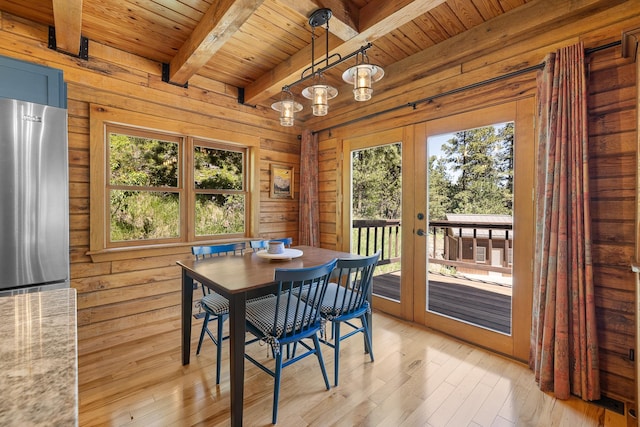 dining space featuring wood ceiling, beamed ceiling, french doors, healthy amount of natural light, and light wood-style flooring