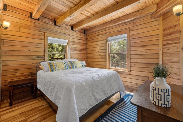 11392 US Highway 14a, Lead, SD 57754 - bedroom with wood ceiling, multiple windows, beamed ceiling, light wood-style flooring, and wood walls