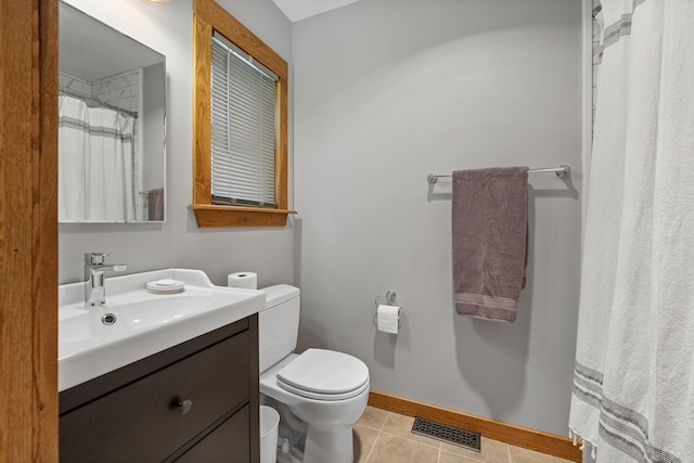 bathroom featuring toilet, vanity, tile patterned floors, and baseboards