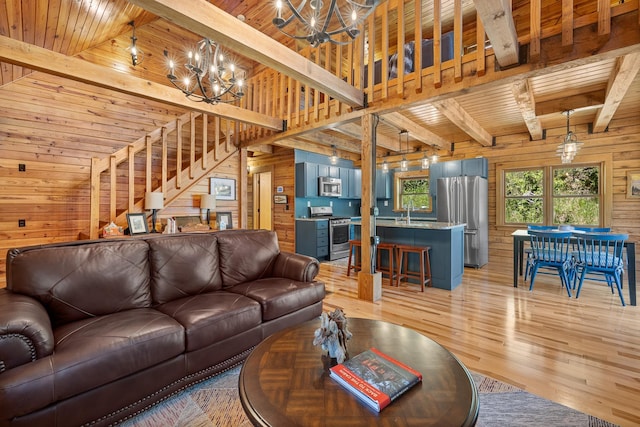living area featuring wood walls, a chandelier, beam ceiling, wood ceiling, and light wood-style floors