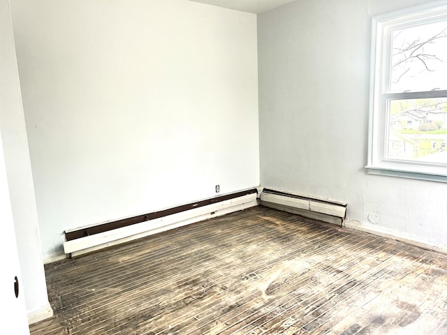 1222 9th Ave, Belle Fourche, SD 57717 - empty room featuring wood finished floors, plenty of natural light, and baseboards