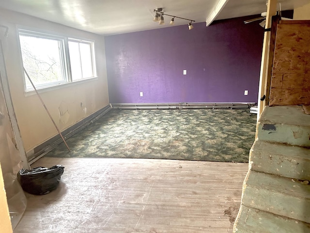 spare room with baseboards and wood finished floors