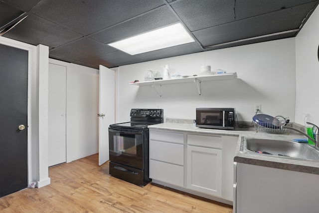 101 E Summit St, Lead, SD 57754 - kitchen featuring black appliances, a sink, white cabinetry, a drop ceiling, and light wood-style floors