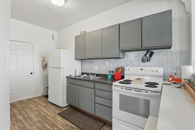101 E Summit St, Lead, SD 57754 - kitchen featuring white appliances, gray cabinetry, wood finished floors, and tasteful backsplash