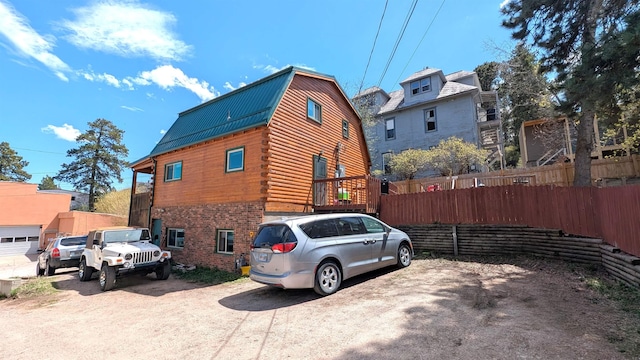 125 S Galena St, Lead, SD 57754 - view of home's exterior featuring a gambrel roof, log exterior, metal roof, and fence