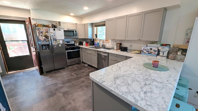 125 S Galena St, Lead, SD 57754 - kitchen with stainless steel appliances, a textured ceiling, gray cabinetry, light countertops, and a peninsula