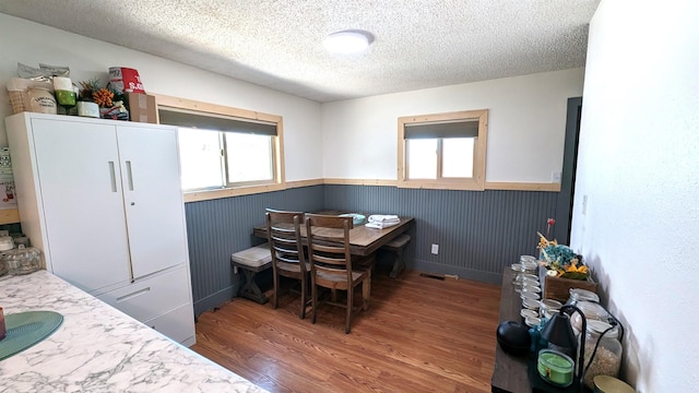 125 S Galena St, Lead, SD 57754 - dining area with wainscoting, a textured ceiling, and wood finished floors