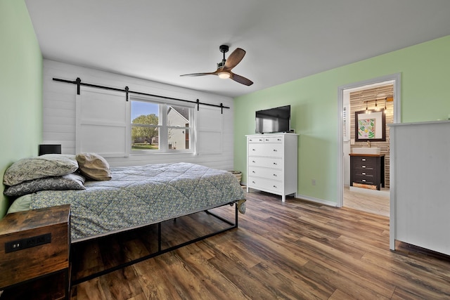 4103 Waterville Ct, Rapid City, SD 57702 - bedroom featuring a barn door, wood finished floors, baseboards, and a ceiling fan