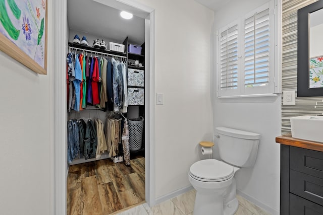 4103 Waterville Ct, Rapid City, SD 57702 - bathroom featuring toilet, baseboards, vanity, and a walk in closet