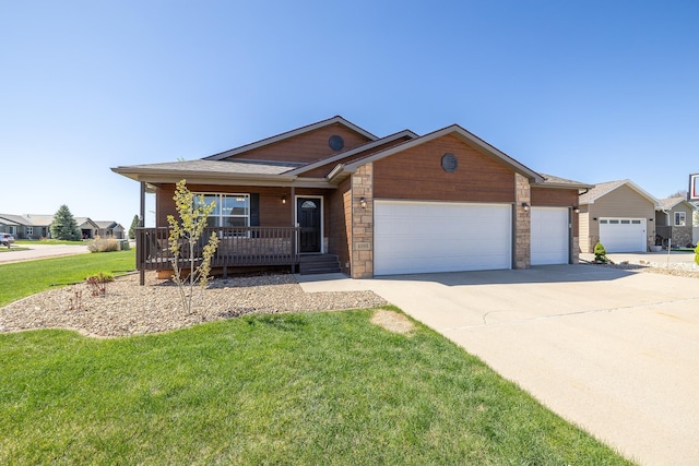4103 Waterville Ct, Rapid City, SD 57702 - view of front of property featuring an attached garage, concrete driveway, a front lawn, covered porch, and stone siding