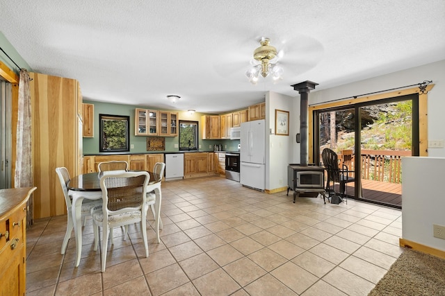 12990 Old Hill City Rd, Keystone, SD 57751 - dining area with a wood stove, ceiling fan, plenty of natural light, light tile patterned floors, and a textured ceiling