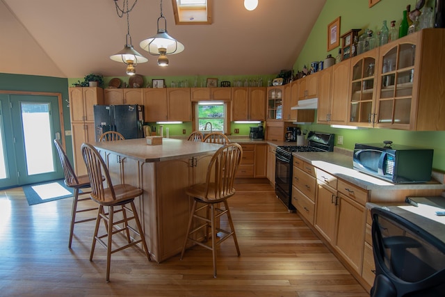 10 Centennial Ave, Deadwood, SD 57732 - kitchen featuring black appliances, light countertops, a breakfast bar area, light wood-style flooring, and under cabinet range hood