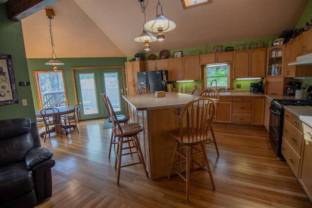 10 Centennial Ave, Deadwood, SD 57732 - kitchen with black appliances, light countertops, under cabinet range hood, glass insert cabinets, and a breakfast bar