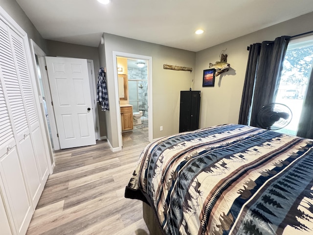 bedroom featuring recessed lighting, light wood-type flooring, ensuite bath, baseboards, and a closet