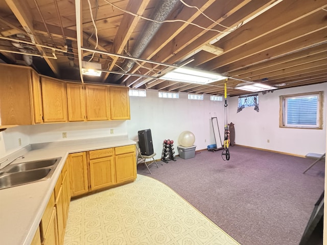 basement featuring a sink and light colored carpet