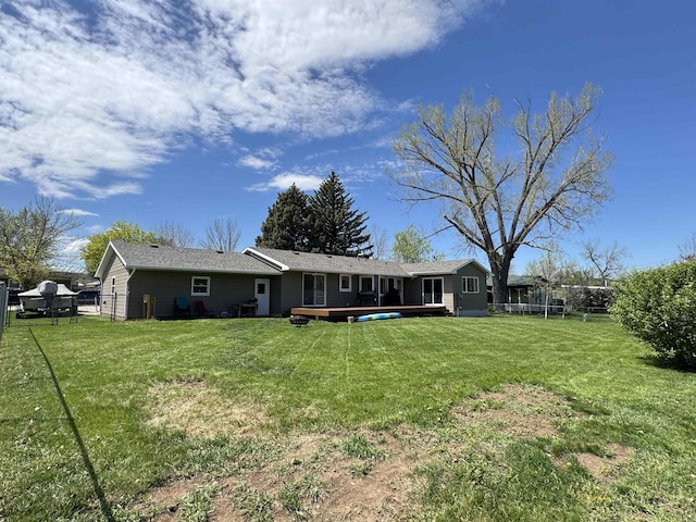 back of house with a deck and a trampoline