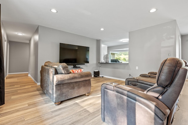 living room featuring light wood-style flooring, baseboards, and recessed lighting