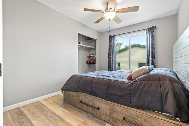bedroom featuring light wood finished floors, baseboards, and ceiling fan
