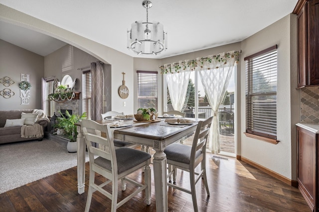 4127 Quiment Ct, Rapid City, SD 57702 - dining space with a chandelier, healthy amount of natural light, dark wood-style floors, and a fireplace