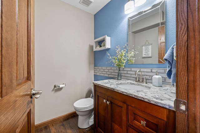 4127 Quiment Ct, Rapid City, SD 57702 - half bath featuring tasteful backsplash, wood finished floors, toilet, vanity, and baseboards
