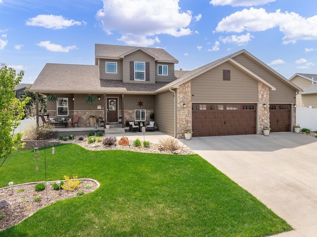 4127 Quiment Ct, Rapid City, SD 57702 - view of front of home with covered porch, a garage, driveway, a front lawn, and stone siding