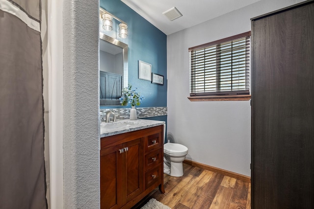 4127 Quiment Ct, Rapid City, SD 57702 - bathroom featuring wood finished floors, toilet, vanity, tasteful backsplash, and baseboards