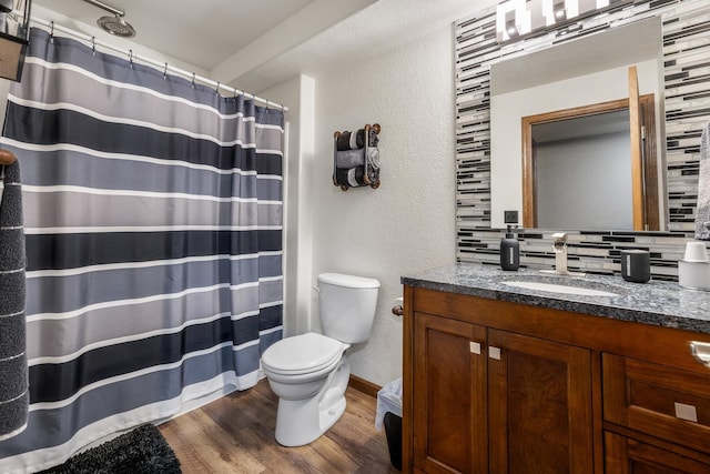 4127 Quiment Ct, Rapid City, SD 57702 - full bathroom with wood finished floors, toilet, vanity, a textured wall, and backsplash