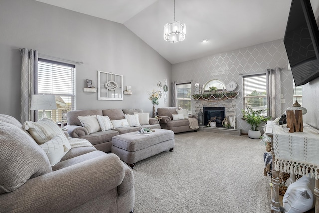 4127 Quiment Ct, Rapid City, SD 57702 - carpeted living room featuring a chandelier, a stone fireplace, and high vaulted ceiling