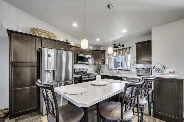 1234 Juneau Dr, Box Elder, SD 57719 - kitchen with appliances with stainless steel finishes, dark brown cabinetry, a sink, light countertops, and a kitchen bar