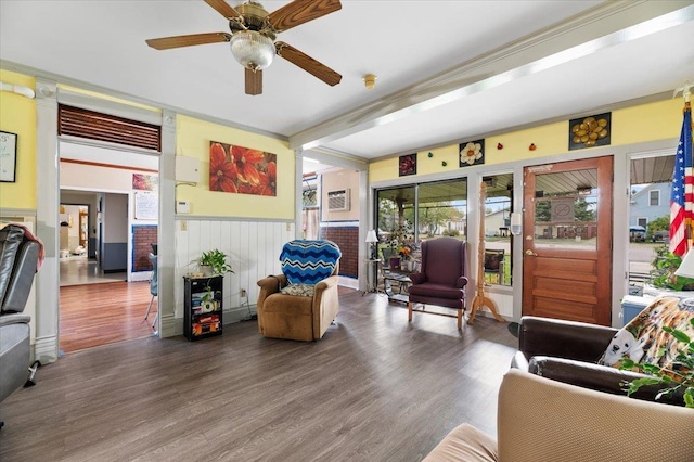 1542 Davenport St, Sturgis, SD 57785 - living room with wood finished floors, a ceiling fan, a wainscoted wall, a wall unit AC, and crown molding