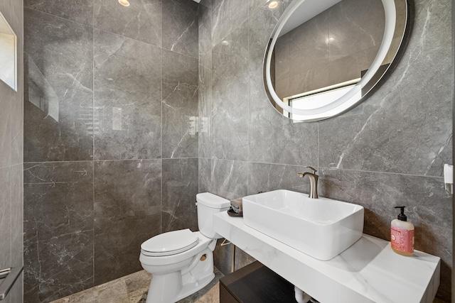 half bath with tile walls, toilet, and a sink
