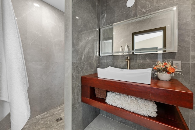 bathroom featuring tile walls, a sink, and walk in shower