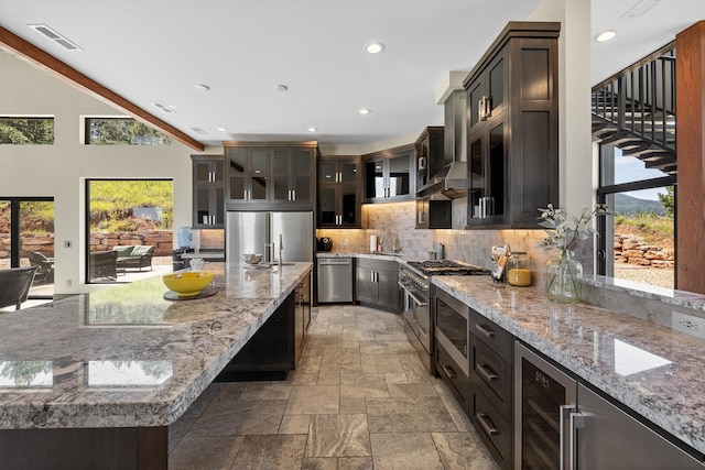 kitchen with appliances with stainless steel finishes, plenty of natural light, backsplash, wine cooler, and recessed lighting