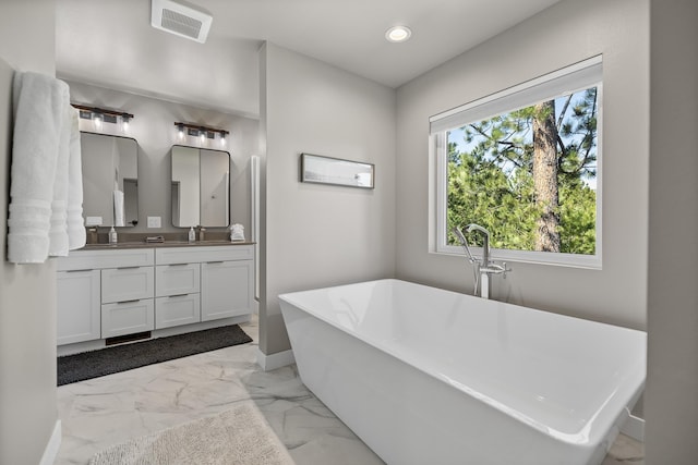 21271 Ridgewood Trl, Lead, SD 57754 - bathroom featuring marble finish floors, double vanity, baseboards, a soaking tub, and recessed lighting