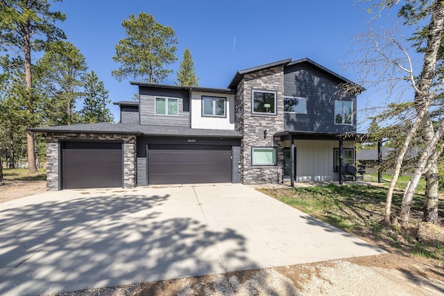 21271 Ridgewood Trl, Lead, SD 57754 - view of front of house featuring concrete driveway, stone siding, and an attached garage