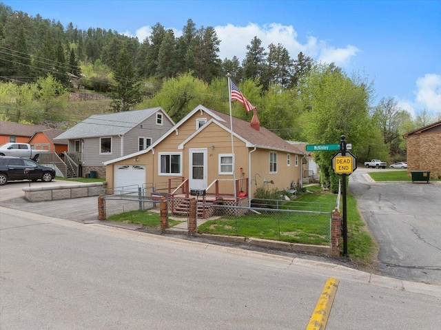 24 Mckinley St, Deadwood, SD 57732 - view of front of house with a fenced front yard, asphalt driveway, and a garage