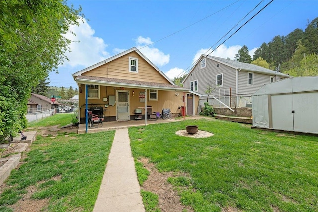24 Mckinley St, Deadwood, SD 57732 - rear view of property featuring an outdoor fire pit, a patio area, a storage shed, and an outdoor structure