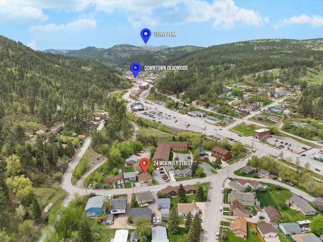 24 Mckinley St, Deadwood, SD 57732 - aerial view of property and surrounding area with a forest, a mountainous background, and nearby suburban area