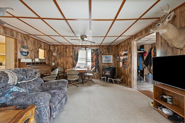 24 Mckinley St, Deadwood, SD 57732 - living area with a wood stove, wooden walls, ceiling fan, and carpet