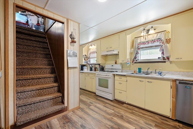 24 Mckinley St, Deadwood, SD 57732 - kitchen with white range with gas cooktop, a sink, under cabinet range hood, cream cabinets, and stainless steel dishwasher