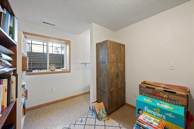 bedroom featuring a textured ceiling and baseboards