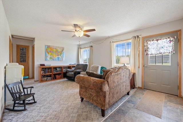 living area featuring a textured ceiling and a ceiling fan