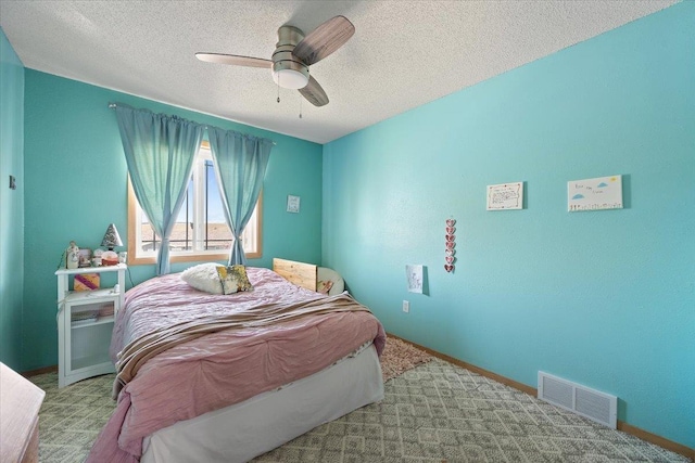 carpeted bedroom featuring a textured ceiling, a ceiling fan, and baseboards
