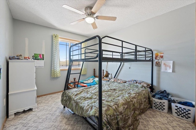 carpeted bedroom with a textured ceiling, baseboards, and ceiling fan