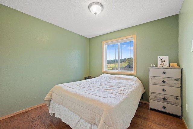 bedroom with baseboards and wood finished floors