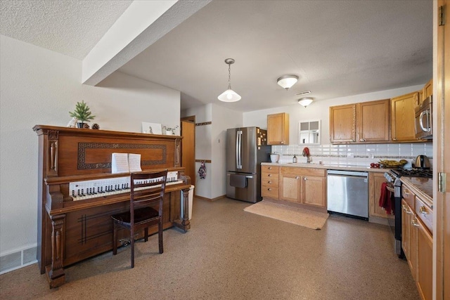 kitchen featuring appliances with stainless steel finishes, backsplash, light countertops, pendant lighting, and baseboards
