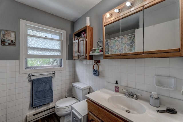 12944 Larene Dr, Black Hawk, SD 57718 - full bathroom with a baseboard radiator, tile walls, toilet, vanity, and wainscoting