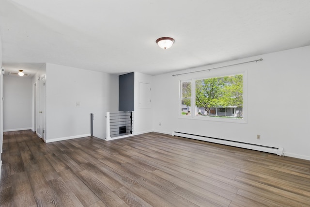 5753 Pluto St, Rapid City, SD 57703 - unfurnished living room with a baseboard heating unit, wood finished floors, and baseboards