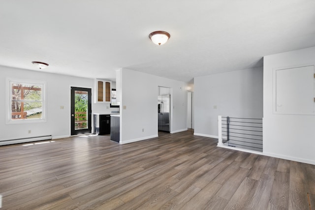 5753 Pluto St, Rapid City, SD 57703 - unfurnished living room featuring wood finished floors, baseboard heating, and baseboards