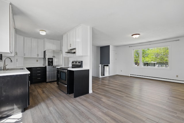 5753 Pluto St, Rapid City, SD 57703 - kitchen with appliances with stainless steel finishes, a sink, under cabinet range hood, dark cabinetry, and light countertops